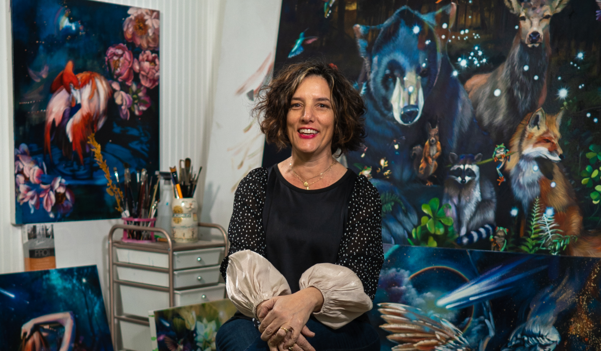 Elli sitting in front of animal paintings 